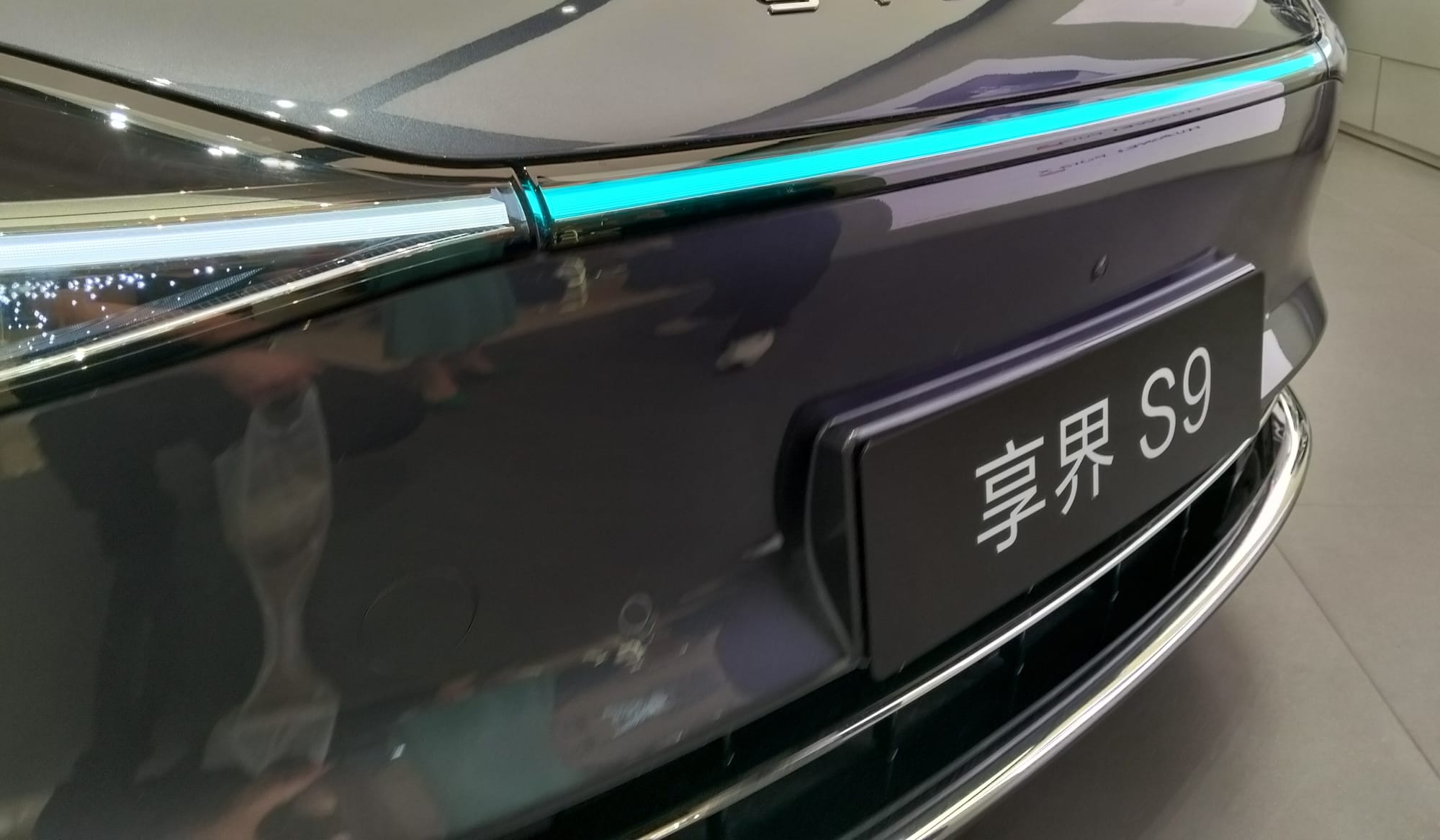 Front bumper of a car with a row of turquoise lights